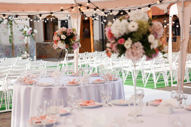 Outdoor tent event with string lights, floral centerpieces, and elegant table settings